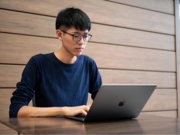 Thammarith working on a laptop